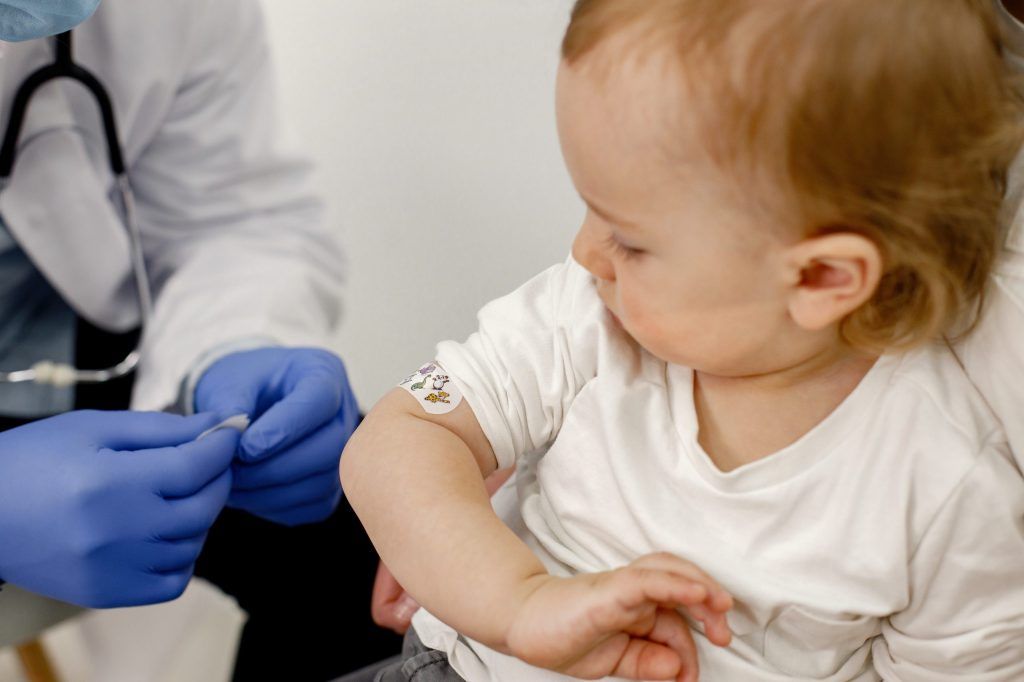 Enfant regarde son bras où un vaccin vient d'être effectué.